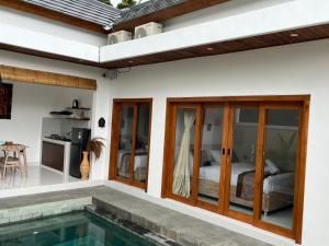 a house with a swimming pool next to a bedroom at Peony Villa Lovina in Lovina