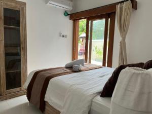 a bedroom with a bed with a laptop on it at Peony Villa Lovina in Lovina