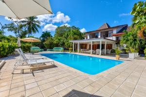 a swimming pool in front of a house at Río Mar Cumayasa in La Romana