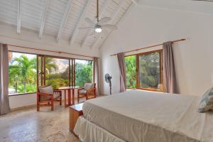 a bedroom with a bed and a table and windows at Río Mar Cumayasa in La Romana +62 photos