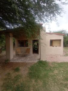 a white house with two chairs and a patio at El Sueñero Tilcara in Tilcara