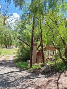 a stone box next to a tree with a sign at El Sueñero Tilcara in Tilcara