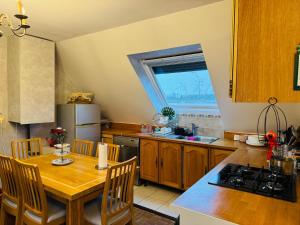 a kitchen with a wooden table and a dining room at Close to Disney & Paris in Lagny
