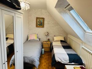 a attic bedroom with two beds and a window at Close to Disney & Paris in Lagny