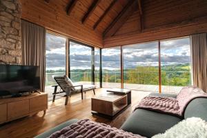 a living room with a couch and a tv andwindows at Vila Podigrac in Zgornja Kungota