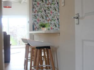 a kitchen with three bar stools and a wallpaper at Sandy Creek Cottage - E5349A in Anderby