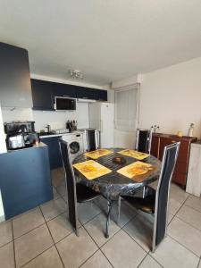 a kitchen with a table and chairs in a room at nice apartment strategic location in Muret