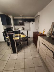 a kitchen with a table and chairs in a room at nice apartment strategic location in Muret +4 photos