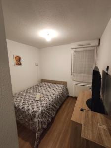 a bedroom with a bed and a desk with a computer at nice apartment strategic location in Muret