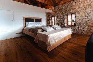 a bedroom with a large bed in a stone wall at Vila Podigrac in Zgornja Kungota
