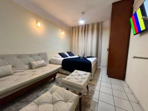 a living room with two beds and a couch at GoHost Suítes - 2 Ruas do Shopping Santa Úrsula in Ribeirão Preto