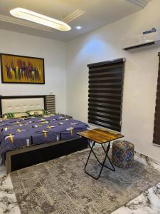 a bedroom with a bed and a table in it at Tranquil in Lekki