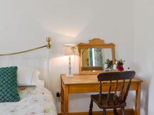 a bedroom with a desk with a mirror and a chair at Cornflower Cottage Ukc1897 in Dogdyke