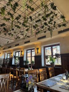 a restaurant with tables and chairs with flowers on the ceiling at Weissenfelder Guest House & Restaurant in Weißenfeld