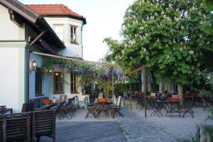 a group of tables and chairs in front of a building at Weissenfelder Guest House & Restaurant in Weißenfeld