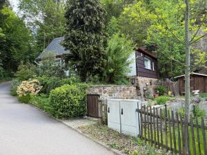 a house with a fence next to a driveway at Waldhaus zur Kleinbahn in Glashütte