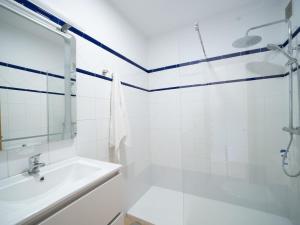 a white bathroom with a shower and a sink at CHL La Mareta, cozy apartment with pool in Breña Baja +12 photos