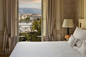 a bedroom with a bed and a window with a view at Beau-Rivage Genève in Geneva