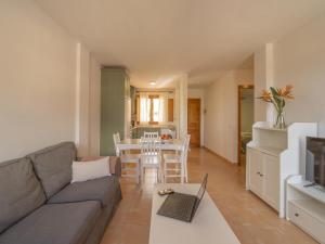 a living room with a couch and a table with a laptop at CHL La Mareta, cozy apartment with pool in Breña Baja