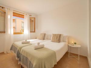two beds in a white room with a window at CHL La Mareta, cozy apartment with pool in Breña Baja