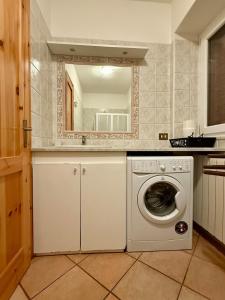 a washing machine in a kitchen with a mirror at Villa crotto Lake View in Perledo