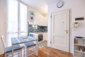 a kitchen with a table and a clock on the wall at Vdoppia Apartment in San Giovanni in Persiceto