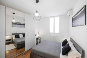 a white bedroom with a bed and a mirror at Vdoppia Apartment in San Giovanni in Persiceto +13 photos