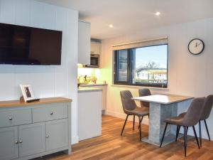a kitchen with a table and chairs and a clock on the wall at Lodge 5 - Uk51086 in Lyme Regis