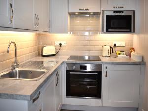 a kitchen with white cabinets and a sink at Lodge 5 - Uk51086 in Lyme Regis