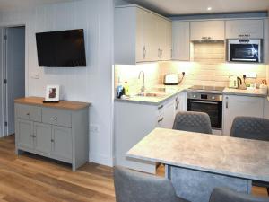 a kitchen with white cabinets and a sink and a table at Lodge 5 - Uk51086 in Lyme Regis