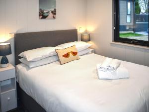 a bedroom with a large white bed with towels on it at Lodge 5 - Uk51086 in Lyme Regis +3 photos