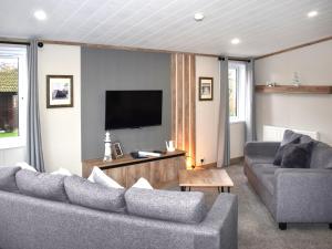 a living room with two couches and a flat screen tv at Lodge 8 - Uk51076 in Lyme Regis