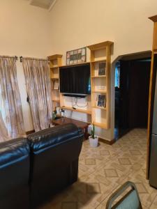 a living room with a couch and a television at Sea View Guest House Apt in Kingstown