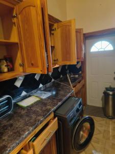 a kitchen with wooden cabinets and a washing machine at Sea View Guest House Apt in Kingstown