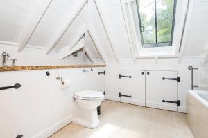 a white bathroom with a toilet and a sink at Coach House in Pembroke