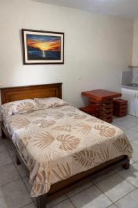 a bedroom with a bed and a table and a picture at Habitaciones amobladas - Manabí suites in Manta