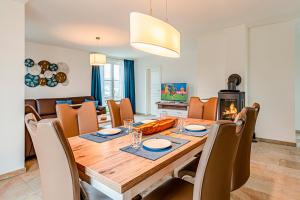 a dining room with a table and chairs and a fireplace at Kramerhof Rügenblick Nr 30 in Parow