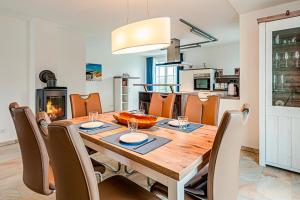 a dining room with a table and chairs and a fireplace at Kramerhof Rügenblick Nr 30 in Parow