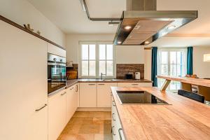 a kitchen with white cabinets and a wooden counter top at Kramerhof Rügenblick Nr 30 in Parow