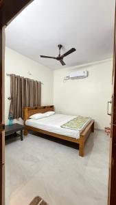 a bedroom with a bed and a ceiling fan at Suraksha Homestay in Malpe +5 photos