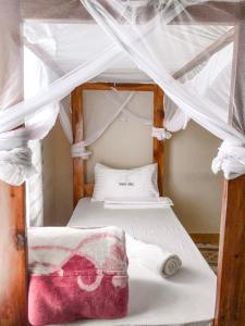 a bedroom with two bunk beds with white curtains at Sisama Lodge in Msaranga