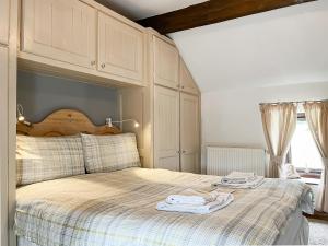 a bedroom with a bed with two towels on it at Honeysuckle Cottage - 27880 in Elton +8 photos