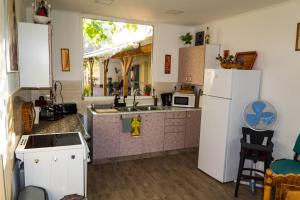 a kitchen with white cabinets and a white refrigerator at Katalin Apartmanok in Hajdúnánás