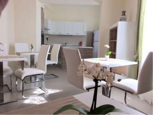 a dining room with white chairs and a table and a kitchen at B&B Bruna in Florence