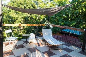 a patio with chairs and a table and a canopy at Katalin Apartmanok in Hajdúnánás