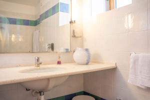 a bathroom with a sink and a vase on a counter at Hotel Rialto in Grado +39 photos
