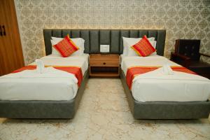 two beds in a hotel room with two twin beds at AAryavarth suites 46 in Pālasmudram +9 photos