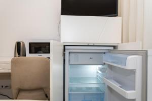an empty refrigerator with its door open in a room at GuestReady - Passal Guesthouse in Ponta Delgada