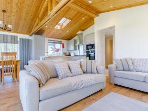a living room with a couch and a kitchen at Nanny Goat Lodge in Crossway Green