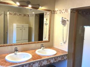 a bathroom with two sinks and a large mirror at Haus Martin Appartement Eichhörnchen in Ramsau am Dachstein